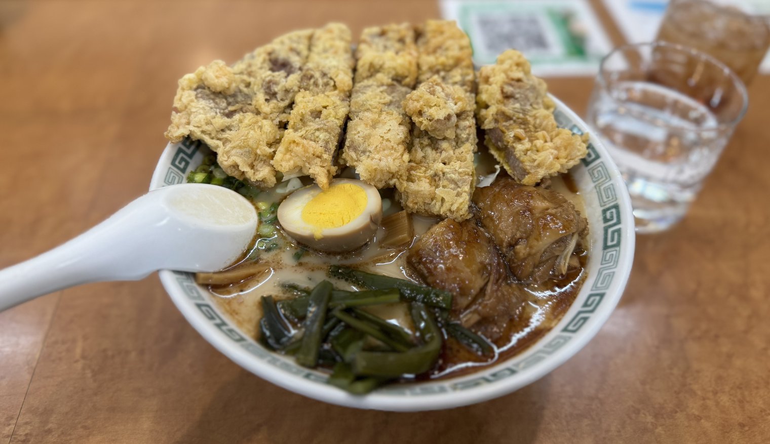 A bowl of ramen stacked with chashu and tempura