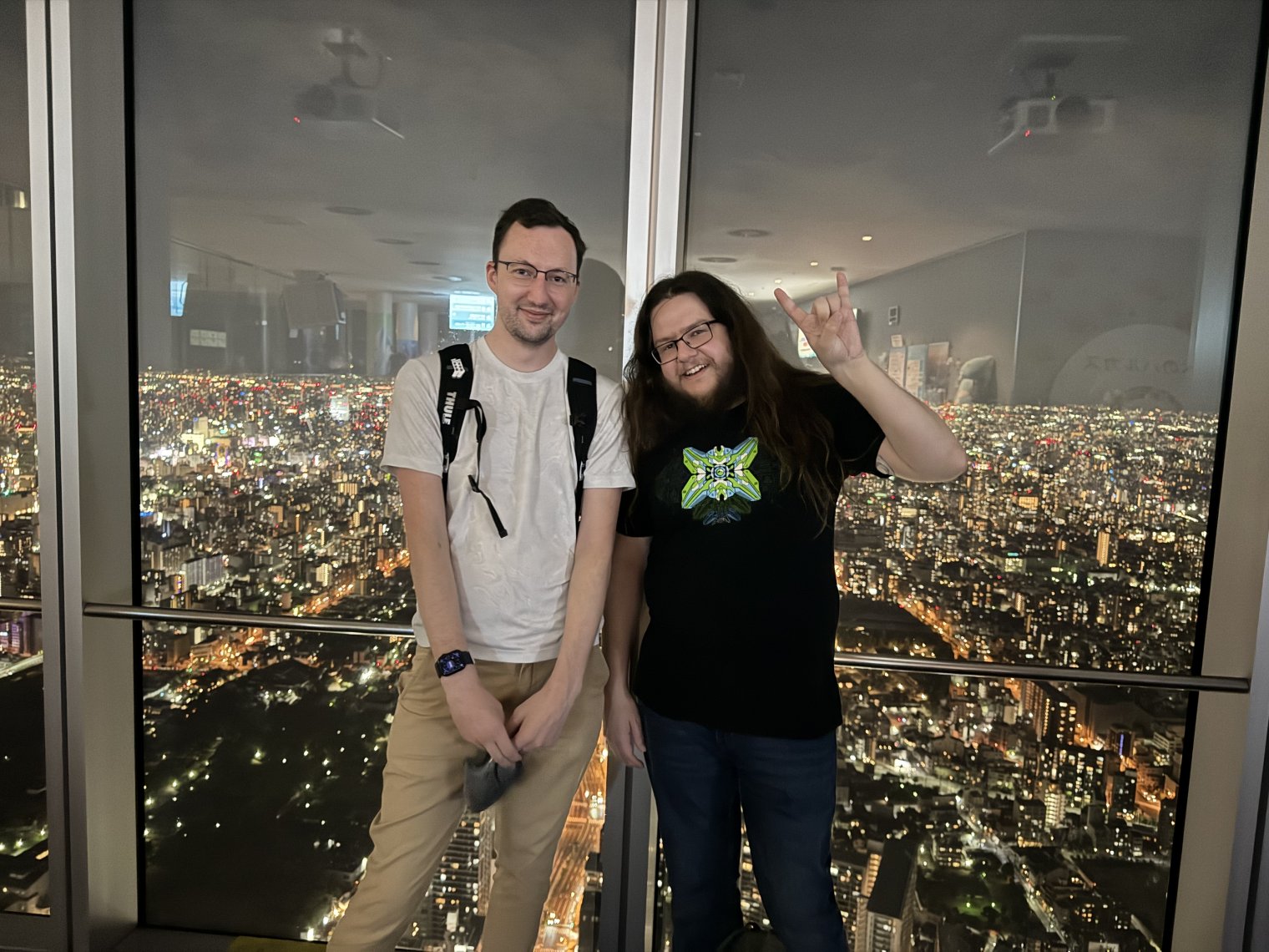 Garion and Stephen posing in front of a panoramic view of central Osaka from the 50th floor in Tennoji